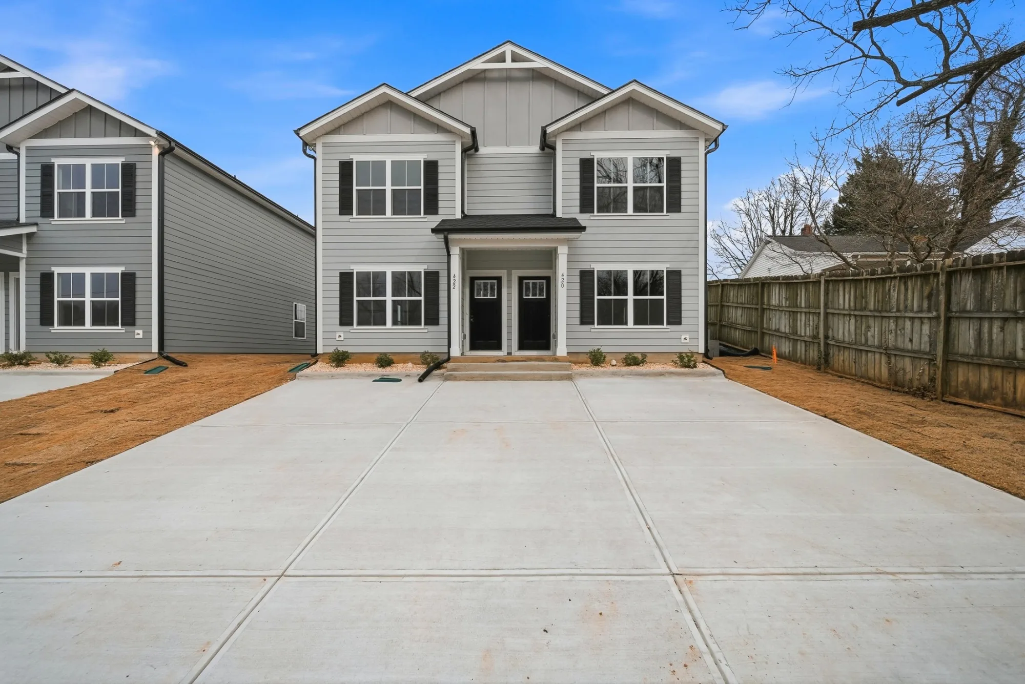 Row of new two-story Legacy Signature Rentals townhomes with covered porches and attached garages