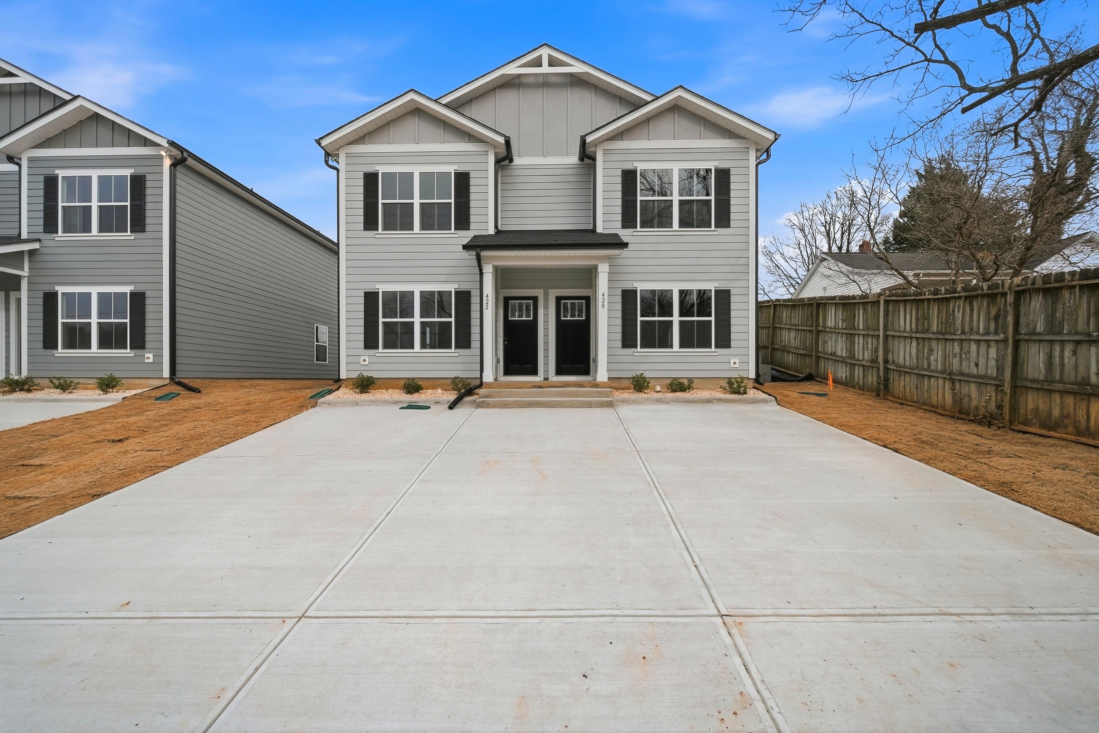 Row of new two-story Legacy Signature Rentals townhomes with covered porches and attached garages